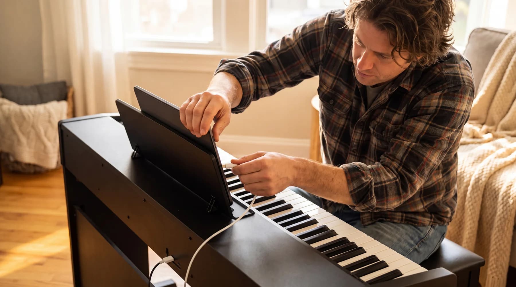 Ein Mann verbindet sein E-Piano per USB-Kabel mit einem iPad